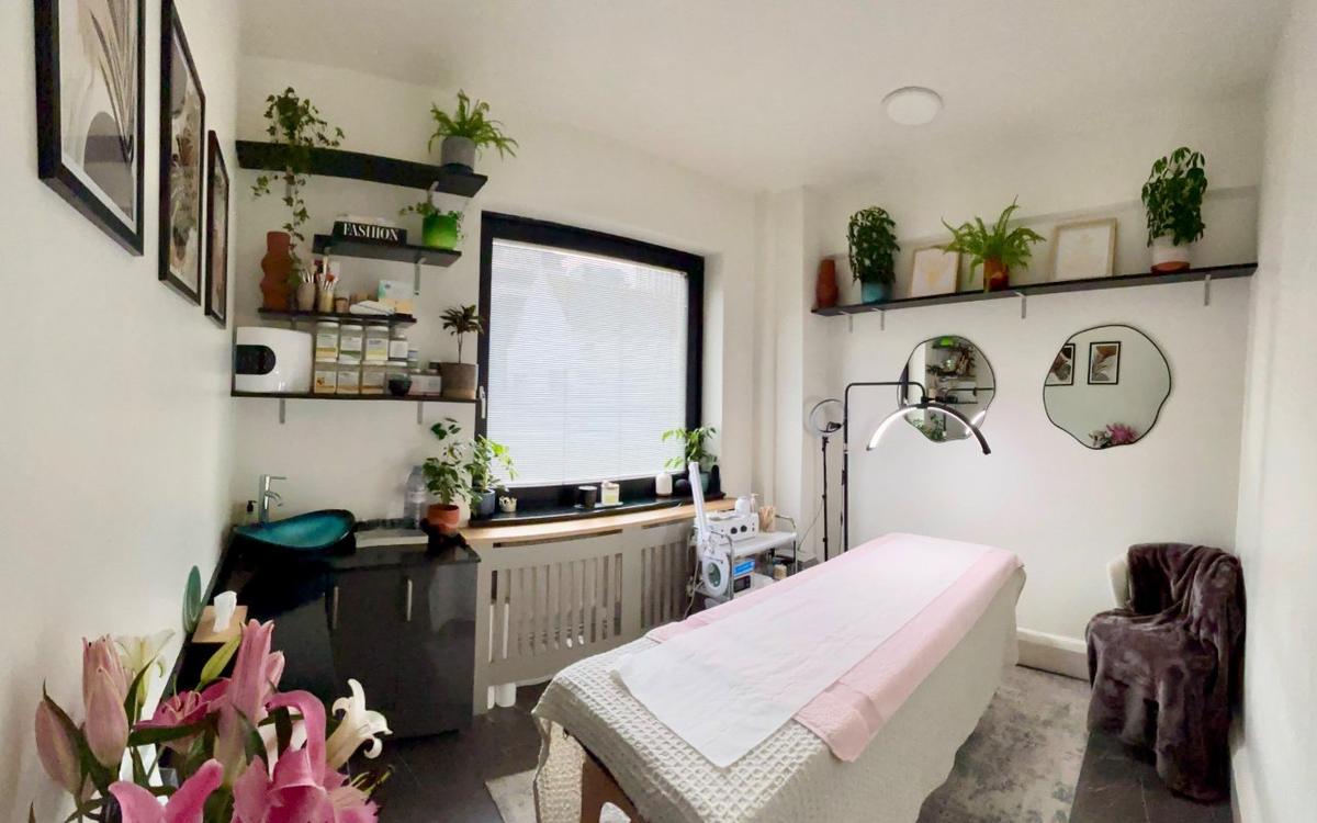 The facial bed at Ela Aesthetic Studio with fresh lilies on the counter